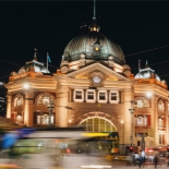 Exterior of Flinders street station lit up with lights on a dark night