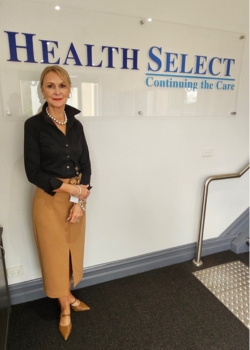 Jeanette Cunningham standing in front of Health Select sign