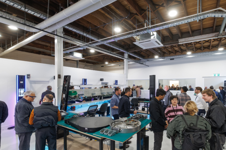 Groups of people gather around software and other equipment