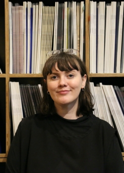 Bridget Smalls standing in front of a shelf of records