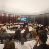 Attendees at a wine tasting event featuring Victorian wines at a famous wine museum in France, with a person presenting at the front near a digital screen.