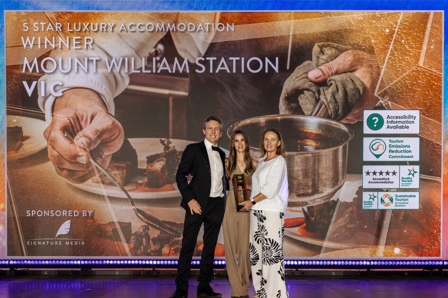 Mount William Station winners of 5 Star Luxury Accommodation Four people posing together at an awards event. One person is holding a trophy. The backdrop displays the text: "Tourism Retail, Hire & Services Winner, Go Adventure Nagambie, Victoria." Several icons and logos are visible on the right side of the backdrop.