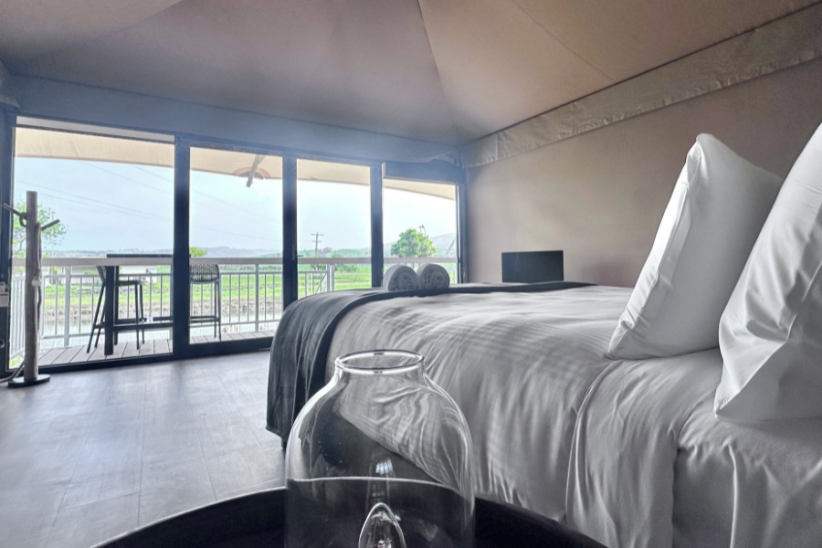 View from bed inside a glamped up tent looking out at view