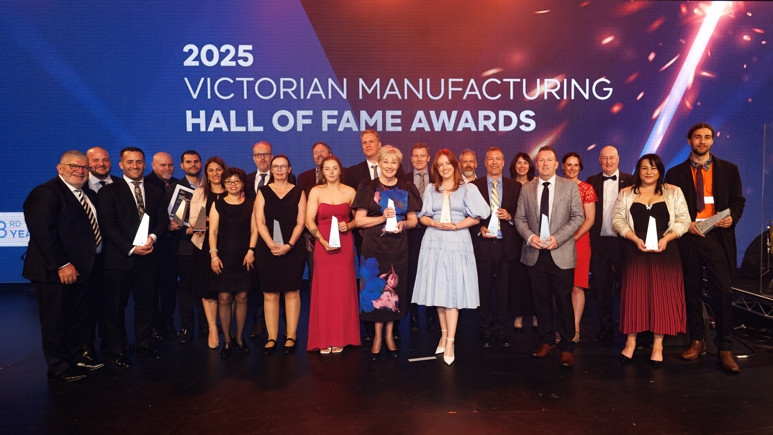 Group of people standing on stage holding awards