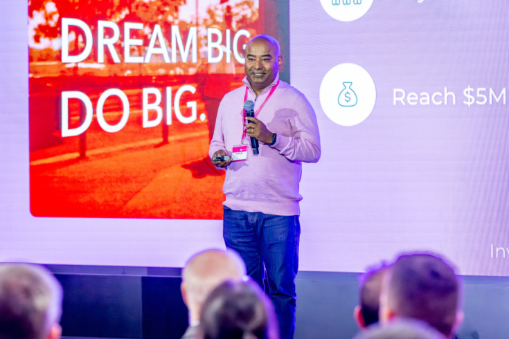 Sushanta Das presenting nrtureAI at CIVVIC with large digital screen behind them displaying words 'Dream Big. Do Big'