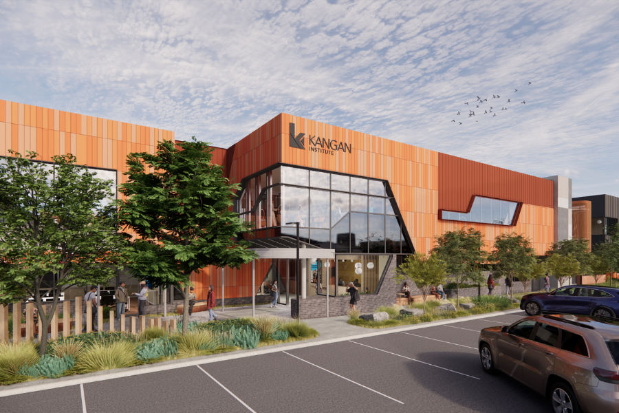 Architectural rendering of Kangan Institute's new Sunbury campus with orange and black exterior. People are walking around and cars are parked outside.