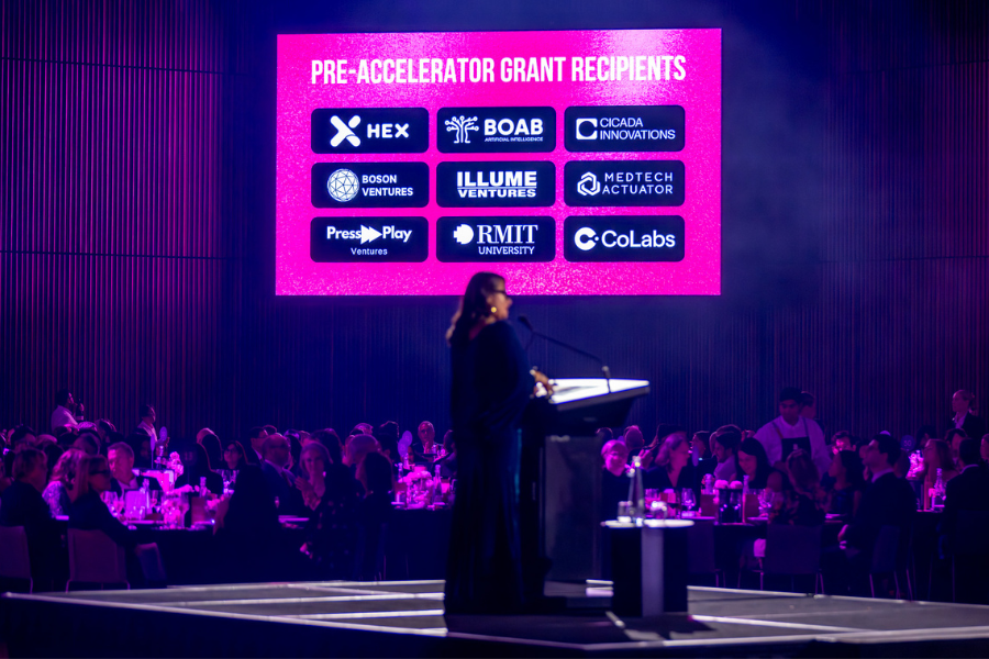 A person in front of a lectern presenting to a room of people