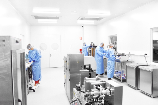 Image of several individuals in protective gear working in a laboratory environment