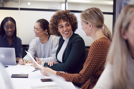 Photo of women sitting in a board room