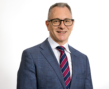 Headshot of Matt Carrick in a business suit