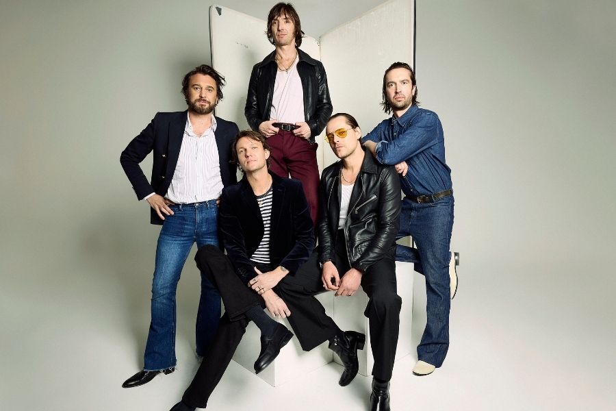 The 5 members of Jet are posing without smiles in a photography studio.
