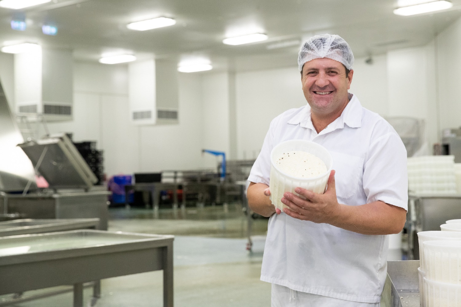 Giorgio Linguanti, Founder of That’s Amore Cheese holding cheese in a cheese factory