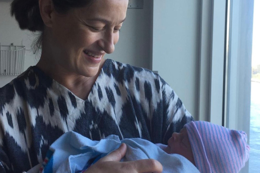 A person smiling and cradling a baby.