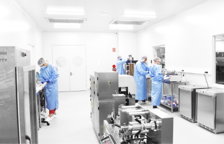 Image of several individuals in protective gear working in a laboratory environment