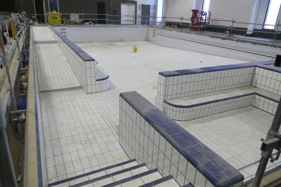 Section of pool being tiled with scaffolding around the sides