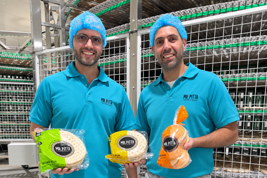 Nick and Angelo Michalidis of Mr Pitta holding their products in a food manufacturing facility
