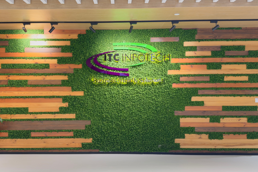 ITC Infotech logo on a wall with fake grass and wooden panels