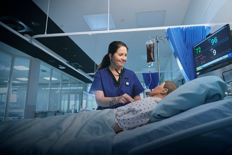 Medical student practising on medical mannequin in a hospital training environment