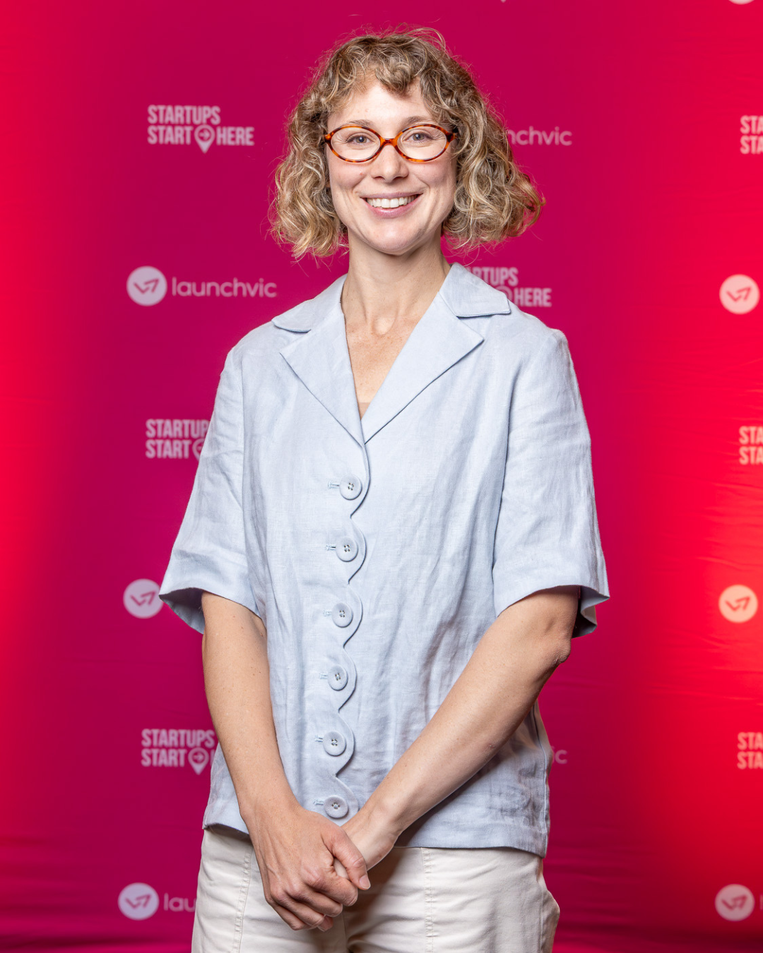Jaye Leighton, founder of The Past Connection platform posing in front of LaunchVic banners