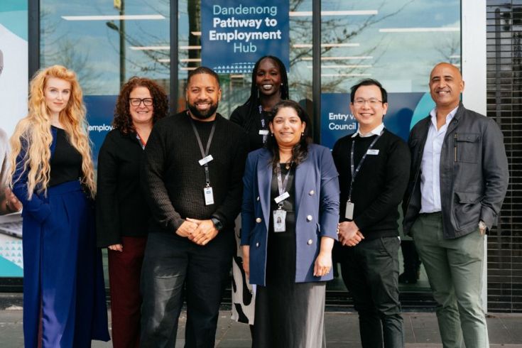 Seven people smile and pose for the camera outside the Dandenong Pathway to Employment Hub