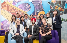 A group of Study Melbourne Hub staff pose in front of artwork