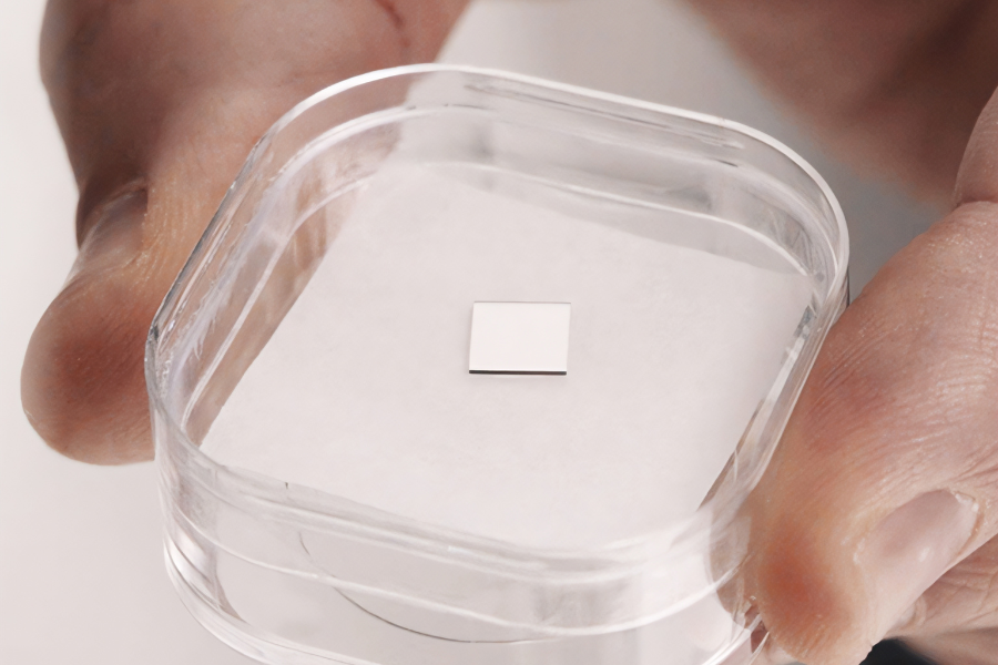 Quantum Brilliance lab-grown diamond in a transparent dish. The diamond is shaped like a microchip