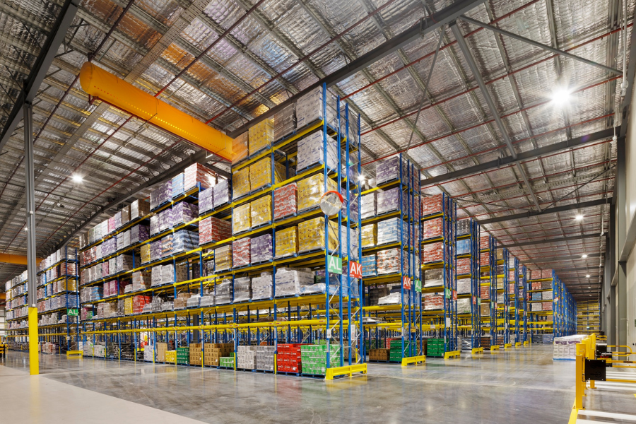 Internal vew of a vast storage warehouse with shelving to roof.